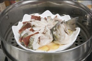 將鱸魚成花狀擺好，將火腿切片放入各縫隙中，放入鍋中隔水蒸12分鐘拿出，撒上蔥花即可。