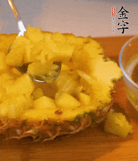 菠蘿對(duì)半切開，切成小方格，用勺子把菠蘿肉挖出來(lái)。用鹽水稍浸泡。