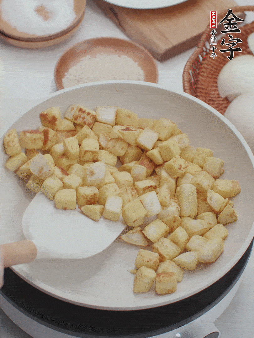 起鍋熱油，倒入饅頭丁，小火煎至蛋液凝固定型再翻面，饅頭丁部煎至金黃時盛起待用。