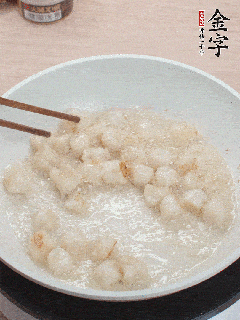 油溫4成熱，鮮貝蘸干淀粉下鍋煎，一面微黃后翻面。