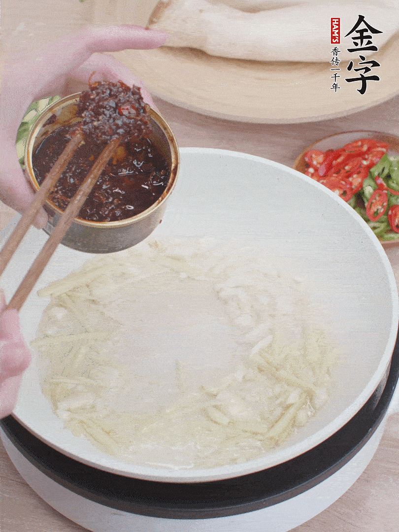起鍋熱油，姜蒜、金字火腿干貝醬煸香。