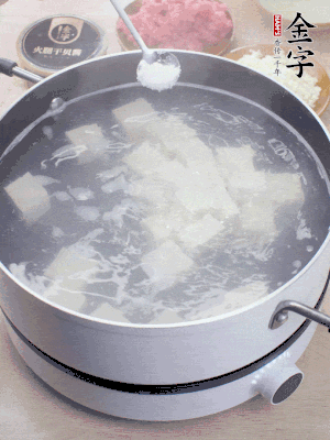 豆腐切成大小均勻正方體，鍋內(nèi)放水，加一點鹽焯水10秒。