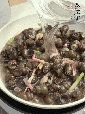 倒處理干凈的螺螄翻炒，加3勺料酒。加清水蓋過螺螄，中火蓋蓋煮5分鐘。