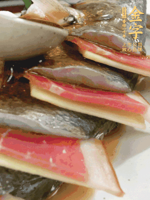 魚肚中塞蔥結、火腿片，魚身上碼放姜片、火腿片，倒入混合的料汁。